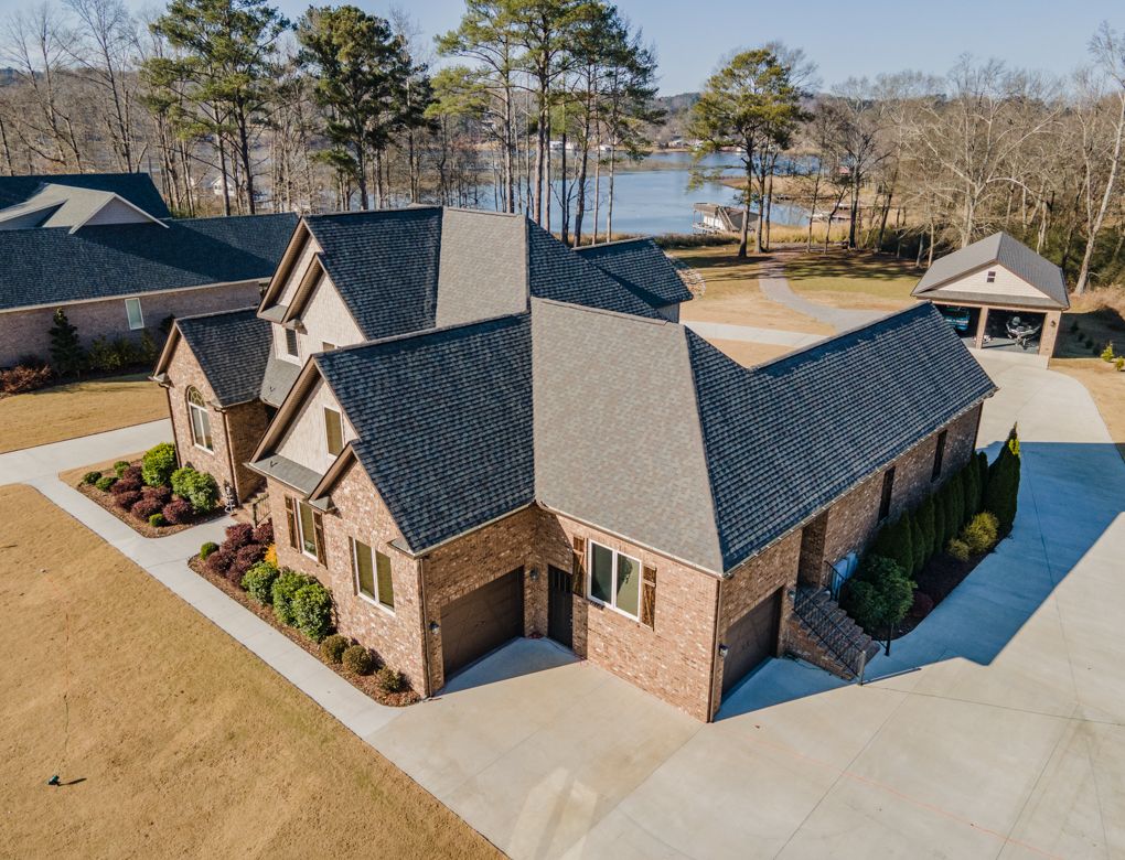 Aerial view of a brick home with a new architectural asphalt shingle roof